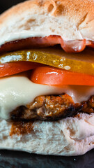 Juicy burger with special rub, melted cheese, onion chutney, crispy bacon, gherkins, and tomato slices. Perfect comfort food for gourmet meals and promotions.