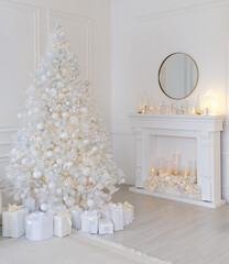 White Christmas interior with decorated tree, glowing garlands, candles, white gifts, elegant festive decor, and a round mirror above a white fireplace.