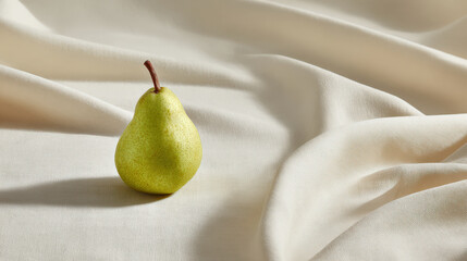 fresh ripe pear rests elegantly against backdrop of soft linen fabric illuminated by ultrabright sunlight