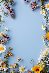 Vertical light blue background framed by fresh wildflowers and colorful daisies creating a cheerful spring border with empty copy space for easter greetings or mothers day card designs.