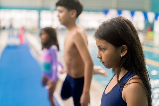 Children preparing for swimming lesson by pool - Powered by Adobe