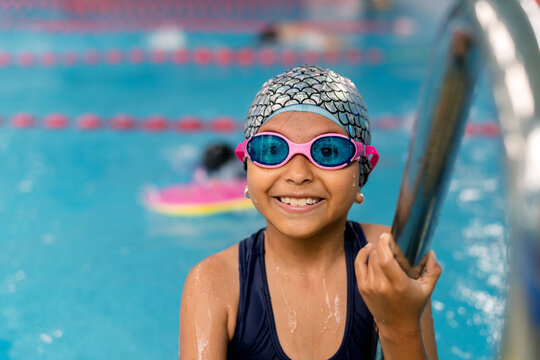 Happy child learning swimming lessons in pool