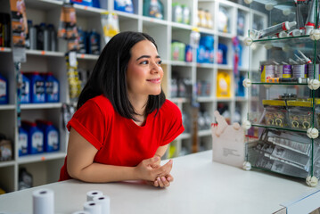 Young woman cashier smiling, providing customer service in an auto parts retail store