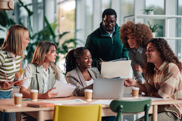 Diverse startup team collaborating on laptop in office