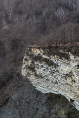 Spring evening landscape in Loazzolo, Asti region, Italy. Rocks and forest illuminated by warm light create a peaceful and natural atmosphere in the scenic Piedmont countryside.