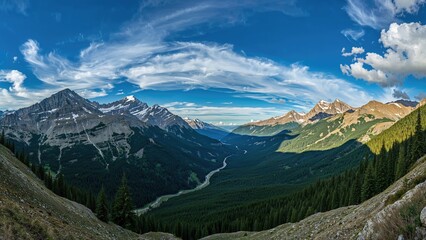 Fototapeta premium Scenic mountain valley view with snow-capped peaks, lush green forests, and cloudy sky.