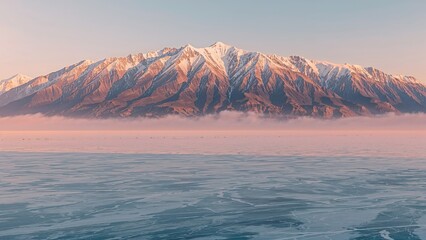 Snow-capped mountains from a distance with fog and icy waters in the foreground. Nature and landscape, scenic view. Mountain and winter landscape.