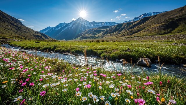 Mountain river valley scene with flowers, green grass, and snow-capped mountains under a bright sun and blue sky.