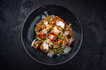 Traditional Italian risotto con finferli with fresh chanterelles and parmesan served as close-up in a Nordic design bowl