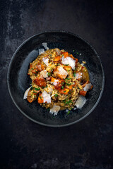 Traditional Italian risotto con finferli with fresh chanterelles and parmesan served as close-up in a Nordic design bowl