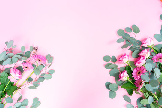 wedding or mothers day background, bouquet of roses and herberas with fresh eucaliptus leaves over plain pink background