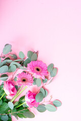 wedding or mothers day background, bouquet of roses and herberas with fresh eucaliptus leaves over plain pink background