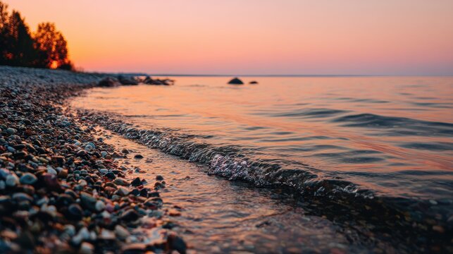 Bay sunset at Toila Oru Park Clear orange sky Wind created ripples Pebbled shore Natural setting Text area