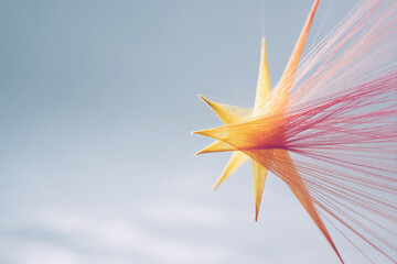 fantastical star made of colorful threads positioned against clean pastelcolored canvas