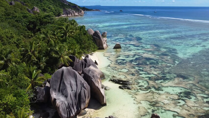 Luxury resort photo of Seychelles tropical paradise islands in Indian Ocean with palm trees, sandy beach, stones. Beautiful photography, coral reef, azure ocean, 
sky with clouds on horizon.  