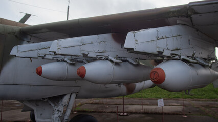 weathered aircraft with underwing fuel tanks, old aircraft resting on grassy field with fuel pods