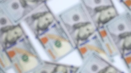 Close-up blurred sequence of hand reaching for scattered banknotes on a flat surface, showcasing the motion and texture of currency, camera zooms in