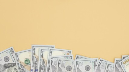 Cash bills are arranged on a flat surface with an airplane model and a piggy bank, illustrating financial planning and travel expenses, camera pans right