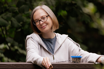Smiling woman enjoying a quiet moment in a lush garden during the peaceful afternoon hours