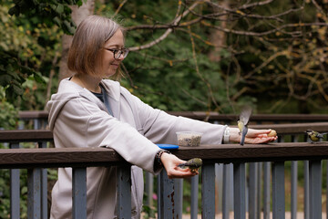 Feeding birds while enjoying nature at a serene park during a sunny afternoon