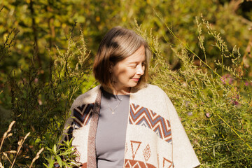 Woman enjoying a sunny day surrounded by lush greenery and wildflowers in a serene natural setting