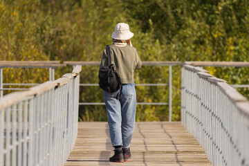 Enjoying a peaceful walk along the wooden path surrounded by vibrant greenery in early autumn