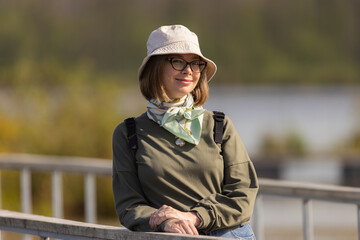 Fashionable young woman enjoys a sunny day by the water while wearing a stylish bucket hat