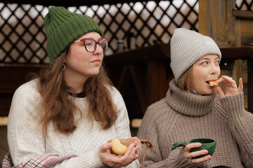 Enjoying a cozy afternoon snack with friends in a rustic cafe during chilly weather
