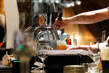 Enjoying a fresh beer poured at a bustling bar during a lively evening gathering with friends