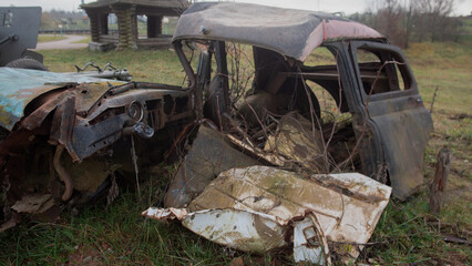 weathered vintage automobile wreckage surrounded by nature and nostalgic countryside atmosphere