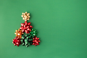 Christmas Gift Bows Forming a Festive Holiday Tree on Green Background &ndash; Red and Gold Ribbon Decorations for Winter 2026