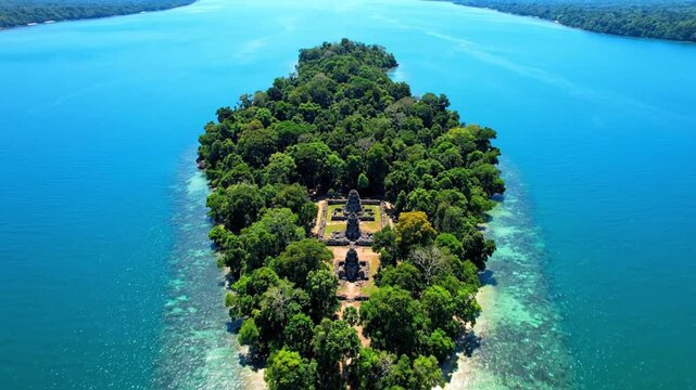 Cinematic aerial view of Neak Pean temple located on small island in middle of reservoir Jayatataka Baray in Cambodia on sunny summer day