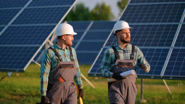 Solar panel farm engineers discussing project blueprint