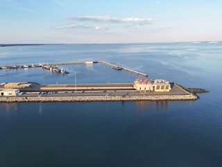 Aerial View Of Long Monitor Merrimac Memorial Bridge Tunnel crossing tranquil blue water of Hampton Roads Channel with a distant harbor and open sky