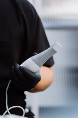 Intraoral dental scanner in gloved hand, modern digital dentistry closeup