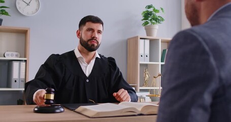 Judge communicates with client or defendant in courtroom, striking hammer to deliver judgment and verdict, focusing on law and decide in a professional court office setting with a sense of authority.