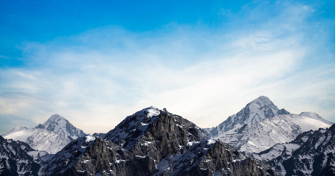 Majestic Snow-Capped Mountains Under a Clear Blue Sky . Outdoor photo of top, height, snow mountains, winter, all in the snow, snow rocks, ultramarine blue sky, sunny sky, mountain top ,snow - Powered by Adobe