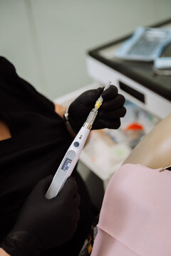 Computerized dental anesthesia injector in gloved hands during patient procedure