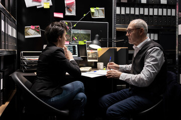 Team of two private detectives investigating an organized crime case with forensic evidence and...