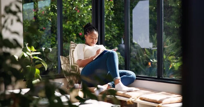 Window, writing and woman with notebook, thinking and planning for story with ideas and inspiration. Creative, author and black person with journal for novel, home or brainstorming with notes on seat