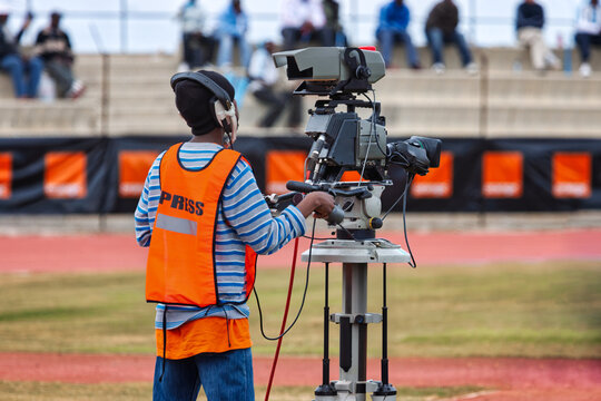 cameraman operator african american with an professional television camera on the field sporting event broadcast media filming