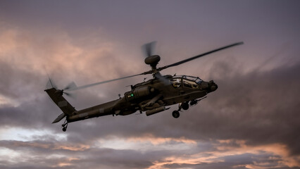 Dark skies as the sun goes down. Attack helicopter on a training flight.