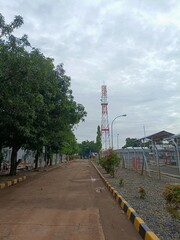a road with wet soil in a gas and oil processing industrial area