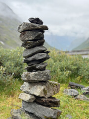 serene cairn amidst misty mountain scenery, rock formation serving as calming trail marker in wilderness