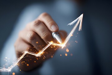 A hand holding a pen draws an upward trend line with sparkles