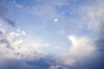Obraz premium Vast blue sky presenting fluffy white and dark grey cumulus clouds, creating a bright opening in the center, symbolizing hope, clarity, and changing weather conditions in nature