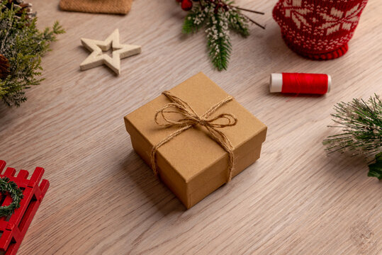 Handmade gift box with twine surrounded by holiday crafting materials, perfect for DIY tutorials, creative workshops and seasonal handmade inspiration.