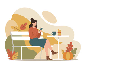 Woman relaxing outdoors in autumn sitting on a bench and using her mobile phone