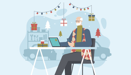 Older man using technology while working remotely in a Christmasdecorated garage