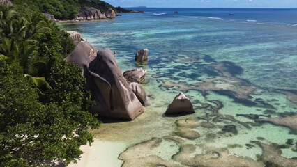 Luxury resort photo of Seychelles tropical paradise islands
in Indian Ocean with palm trees, sandy beach, stones.
Beautiful photography, coral reef, azure ocean, 
sky with clouds on horizon. 